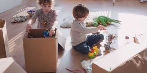 Family packing and moving with kids in a bright playroom.
