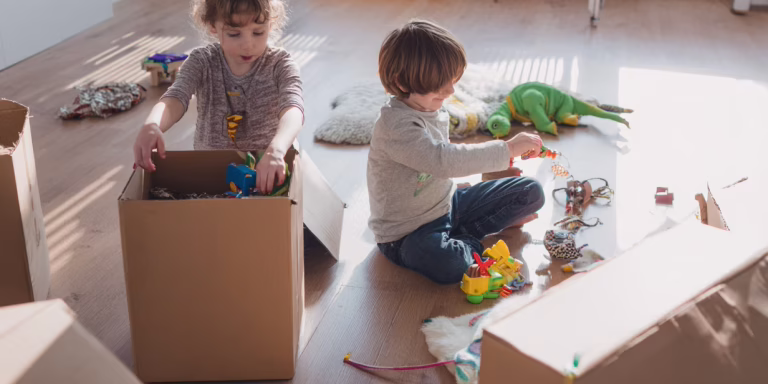 Family packing and moving with kids in a bright playroom.