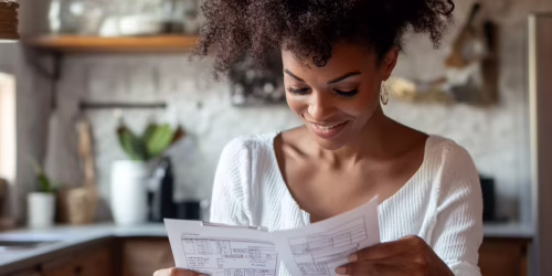 Woman smiling, calculating moving estimates in her Ohio home.